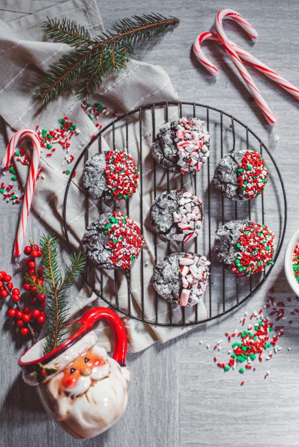 peppermint chocolate crinkle cookies with candy canes, green pine, sprinkles and a santa mug
